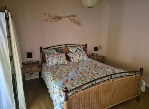 a bedroom with a bed and two night stands with lamps at Gîte Marie, Beynat, Corrèze in Beynat