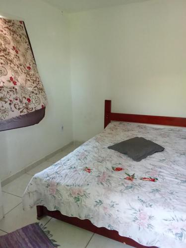a bedroom with a bed with a floral comforter at Refúgio à beira mar in Serra