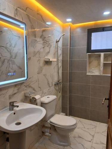 a bathroom with a white toilet and a sink at Casa youssef 2 in Asilah