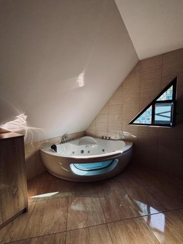 a bathroom with a large tub in a attic at Vila Antanta Podu' Cu Lanturi in Bacău