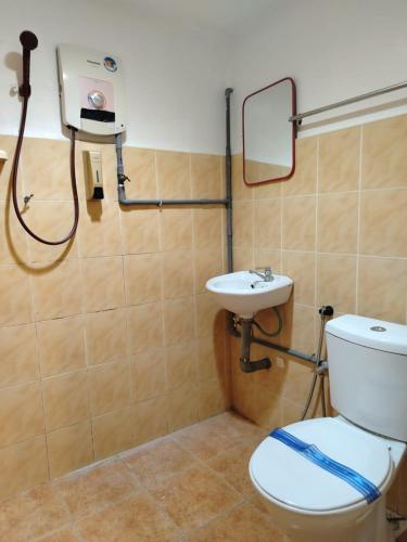 a bathroom with a toilet and a sink at Tanjong Boutique Hotel in TanjongMalim