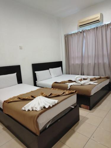 two beds sitting next to each other in a room at Tanjong Boutique Hotel in TanjongMalim