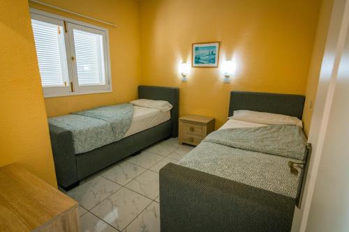 a room with two beds and a window at Aparthotel MONTERREY in Puerto Rico de Gran Canaria