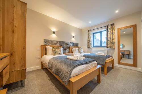 a bedroom with two beds and a mirror at Parklands in Penrith
