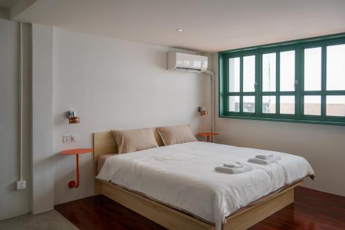 a bedroom with a large bed with a window at Arunne in Bangkok Yai