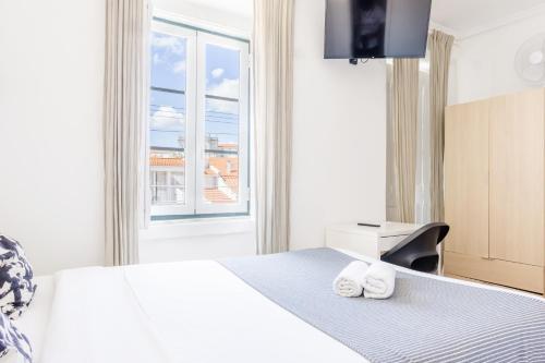a bedroom with a large bed with a window at Suites - Elevador da Bica in Lisbon