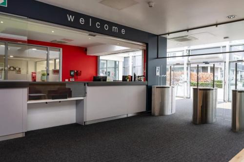 an office lobby with a counter and a red wall at Fitzroy Court near Luton Airport in Luton