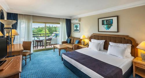 a hotel room with a bed and a television at The Norm Oriental Kemer in Kemer