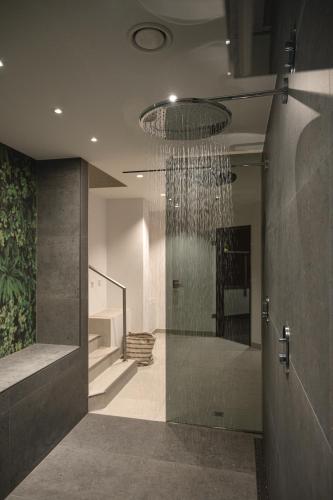 a bathroom with a chandelier hanging from the ceiling at Hotel VierJahreszeiten am Seilersee in Iserlohn