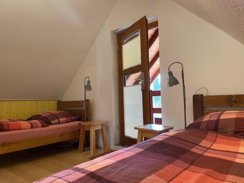 a bedroom with two beds and a window at Ferienhaus Wehretal - auf separatem Grundstück in Langenhain