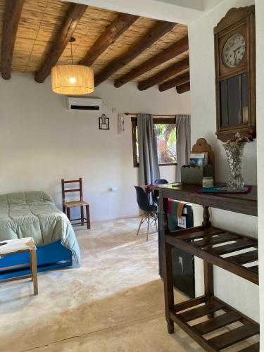 a bedroom with a bed and a clock on the wall at La Amanecida Tilcara Cabañas in Tilcara