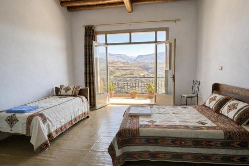 a bedroom with two beds and a large window at Birhanu Guest House and Tours in Lalibela
