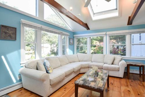 a living room with a white couch and windows at Private Pool Large Deck and Game Room in Dennis