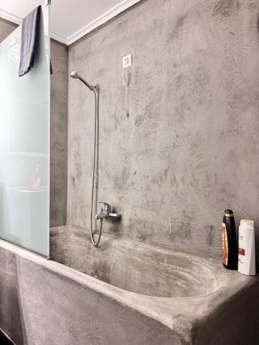 a bathroom with a bath tub with a shower at Relax - Patras Apartment in Patra