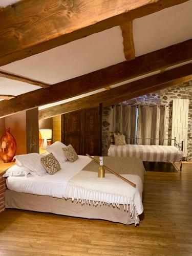 a large bedroom with two beds in a room at Restaurant et Chambres d'Hôtes La Ferme de Cornadel in Anduze