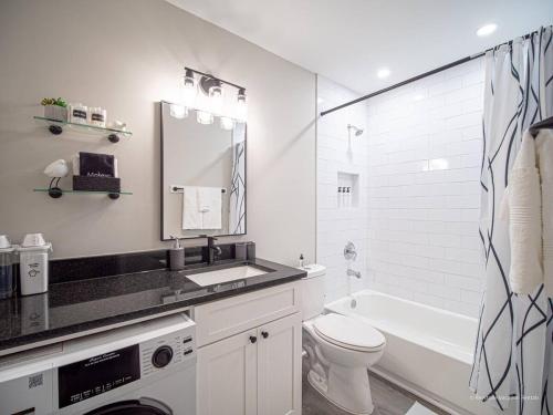 a white bathroom with a sink toilet and a mirror at The Battery Hideaway in Marietta