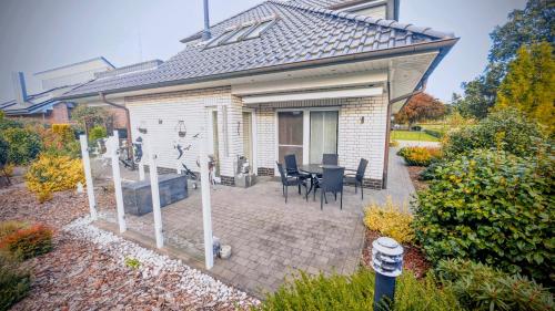 a house with a patio with a table and chairs at Ferienwohnung Witte Huus, 15212 in Leer