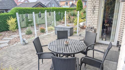 a patio with a table and chairs and a grill at Ferienwohnung Witte Huus, 15212 in Leer