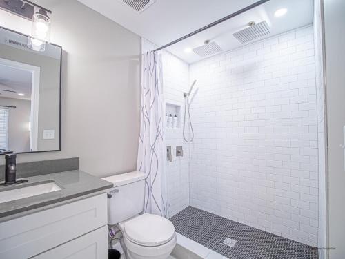 a white bathroom with a shower and a toilet at The Franklin in Marietta in Marietta