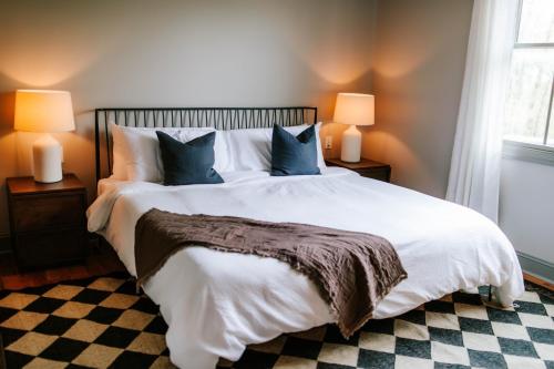 a bedroom with a large white bed with two lamps at BEAUTIFUL Jasper Highlands Cabin - AZALEA in Jasper
