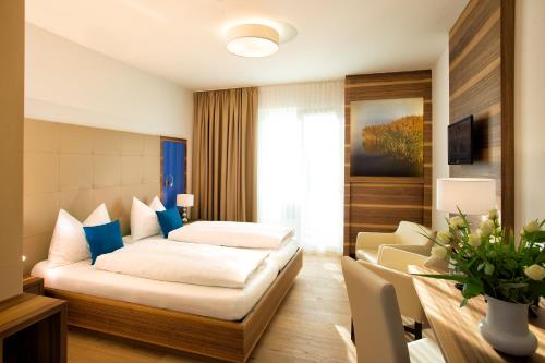 a hotel room with a bed and a couch at Hotel Wende in Neusiedl am See