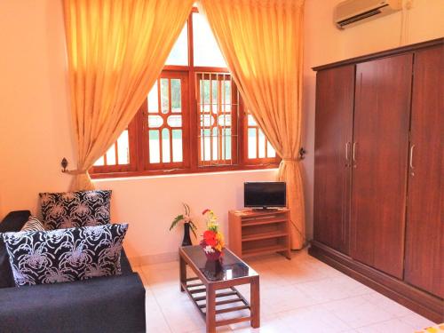 a living room with a couch and a tv at Romeo and Juliet Guest House in Negombo