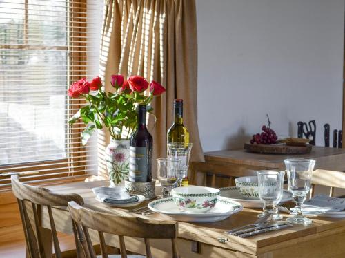 a dining room table with a bottle of wine and flowers at Shedend in Kingston