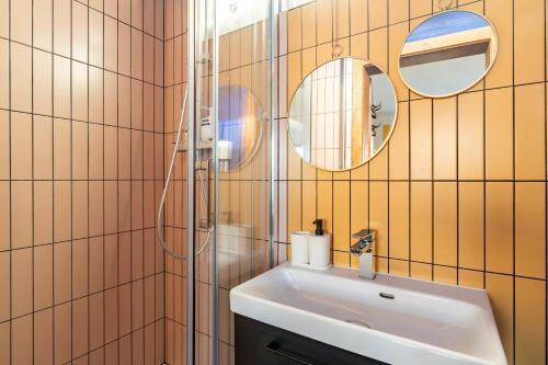 a bathroom with a sink and two mirrors at Strasbourg Evasion Pop in Strasbourg