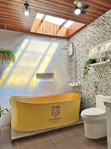a bathroom with a yellow tub next to a toilet at Heaven staycation in Angeles