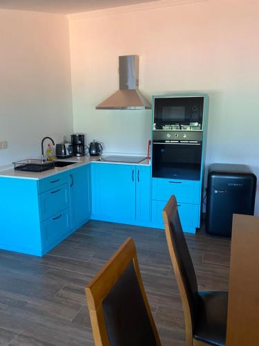 a kitchen with blue cabinets and a microwave at Casa de São Luís - Turismo Rural in Torre de Moncorvo