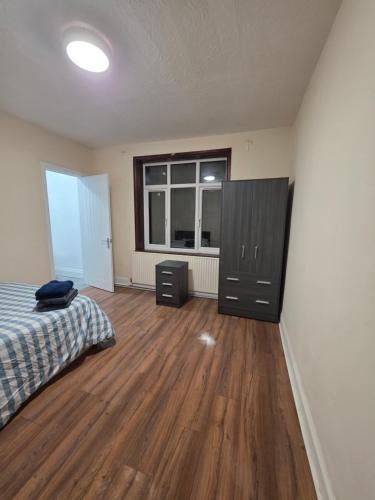 a bedroom with a bed and a dresser and a window at ELI STAY Ensuite rooms in Ipswich