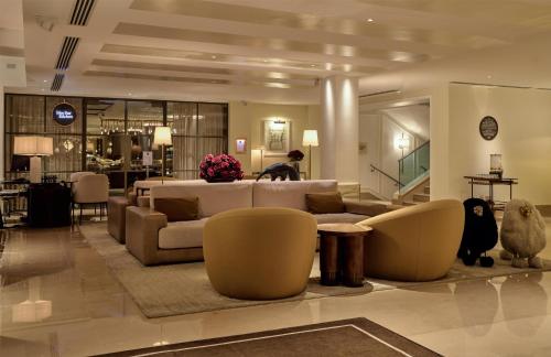 a living room with couches and chairs in a lobby at The May Fair Hotel, Mayfair, London in London