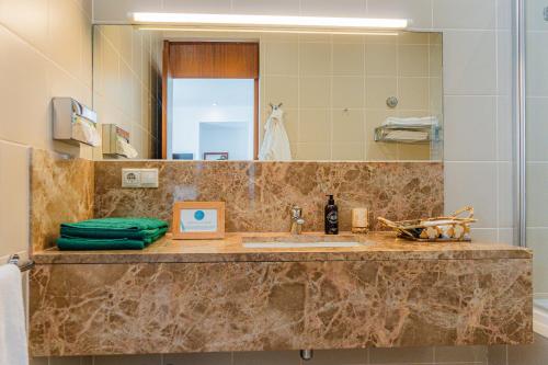 a bathroom counter with a sink and a mirror at Quinta do Mar in Água de Pau