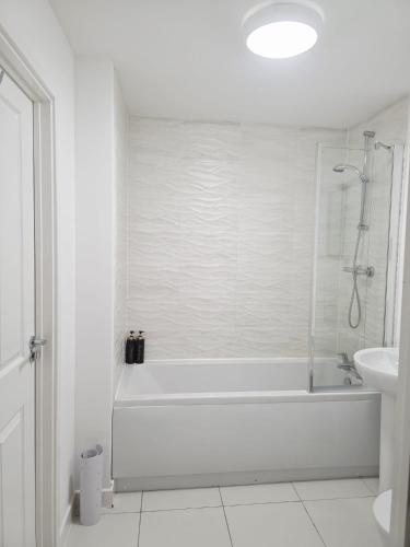 a white bathroom with a tub and a sink at Newcastle Upon Tyne View Haven in Newcastle upon Tyne