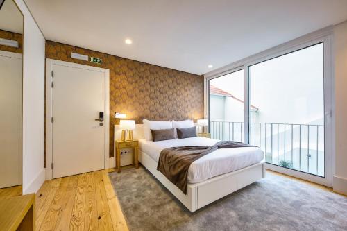 a bedroom with a large bed and a large window at Avenue Garden in Coimbra