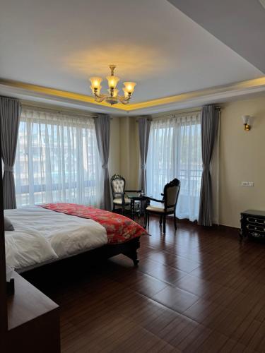 a bedroom with a bed and a table and chairs at Tashi Tagay Hotel & Apartment in Kathmandu