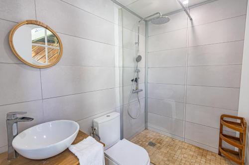 a bathroom with a sink and a toilet and a mirror at Duplex mezzannine vue marina in Le Gosier