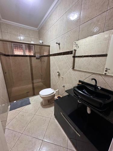 a bathroom with a toilet and a sink at Paraiso Particular Piscina e Ar Condicionado in Americana