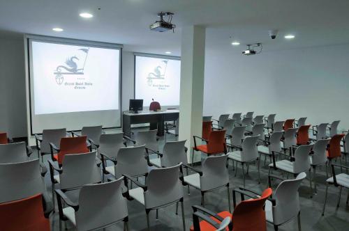 a room filled with chairs and a projector screen at Grand Hotel Italia in Orvieto