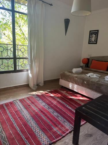 a living room with a bed and a red rug at Fekhara CC in Marrakesh