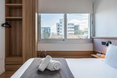 a hotel room with a bed with towels on it at Cozy luxury 1-bedroom in Nicosia’s heart in Nicosia