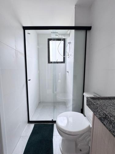 a white bathroom with a shower and a toilet at apartamento ana julia modesto in Juazeiro do Norte