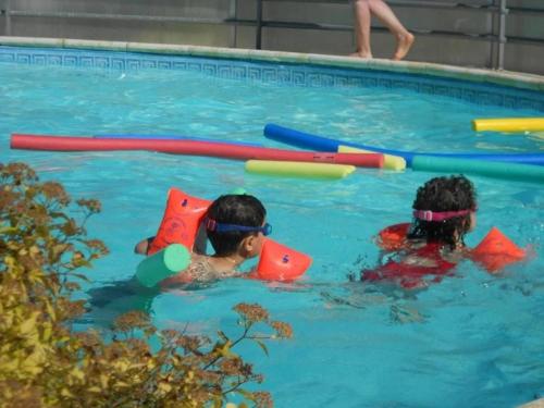 two children playing in a swimming pool with toys at ZEcamping 4 étoiles chiens acceptés tennis piscine chauffée in Salles-Curan