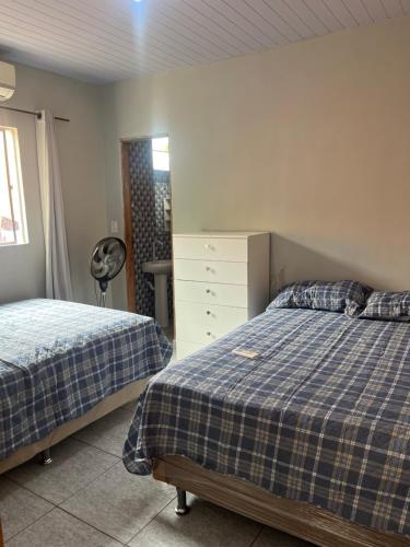 a bedroom with two beds and a dresser at Meu cantinho 5 in Santarém