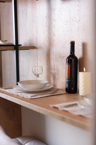 a bottle of wine sitting on a table with a glass at Gaia Apartments in Mytilene