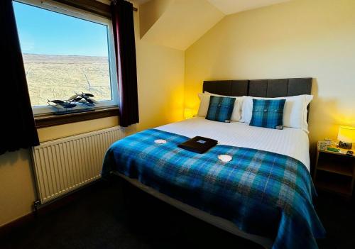 a bedroom with a bed with a large window at SEAcroft Licensed B&B and Restaurant in Aird Uig
