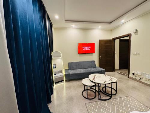 a living room with a blue couch and a table at Stay Premium in Islamabad