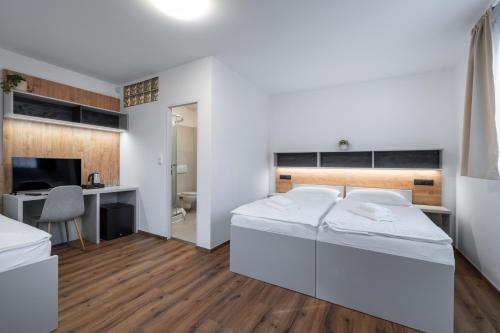 a bedroom with two beds and a desk at Oaza Ricany in Ricany