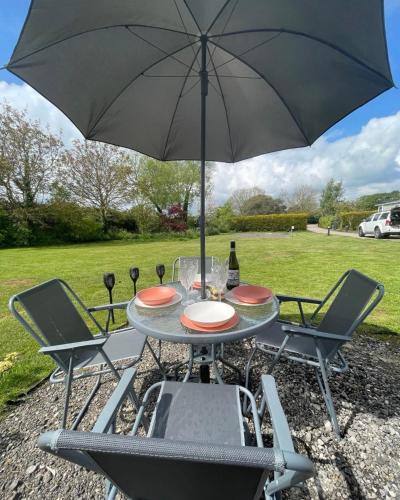 a table and chairs with an umbrella in a yard at The Old Inn Retreat in Spilsby