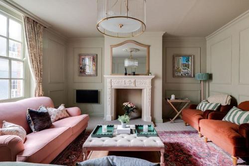 a living room with pink couches and a fireplace at Luxury House - Walk to Racecourse - Sleeps 10 in Chester